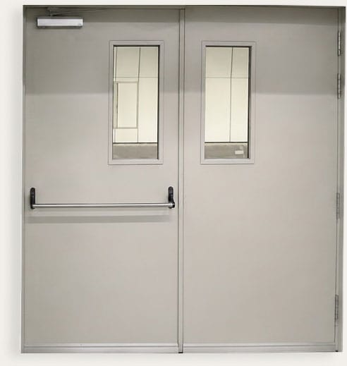Double egress steel door with vision panels in each leaf and a push bar