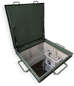 Floor hatch steel door hinged open at an angle, showing the access ladder