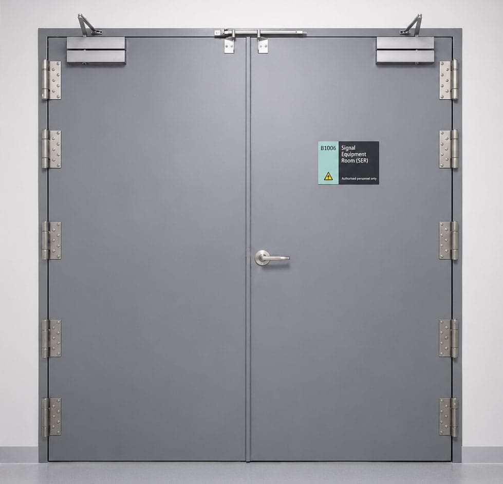 Grey double-leaf blast resistant steel door labelled Signal Equipment Room (SER)
