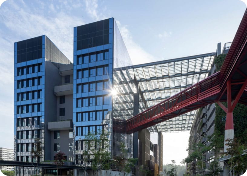 Modern building with a red steel skybridge and glass canopy