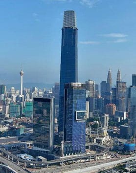 Tall skyscraper rising above the Kuala Lumpur skyline at sunset